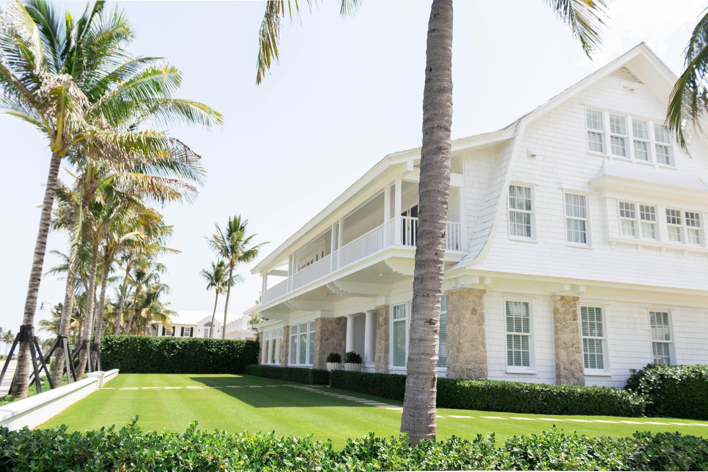 Palm trees framing a bright coastal home in Palm Beach
